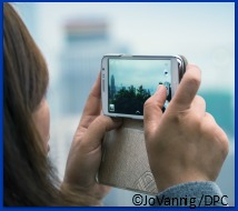 Woman taking city picture with her smartphone.